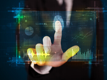 Stock image of a hand touching computer screen with graphs and charts